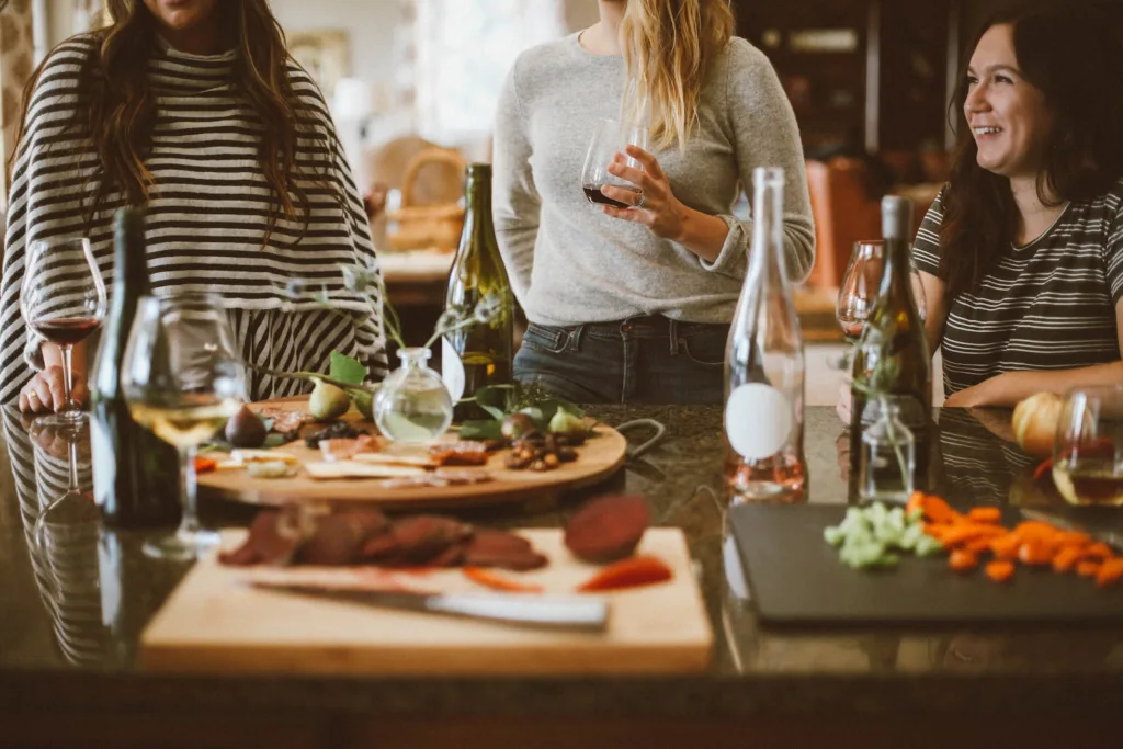 two woman standing beside woman sitting in front of table - 11society