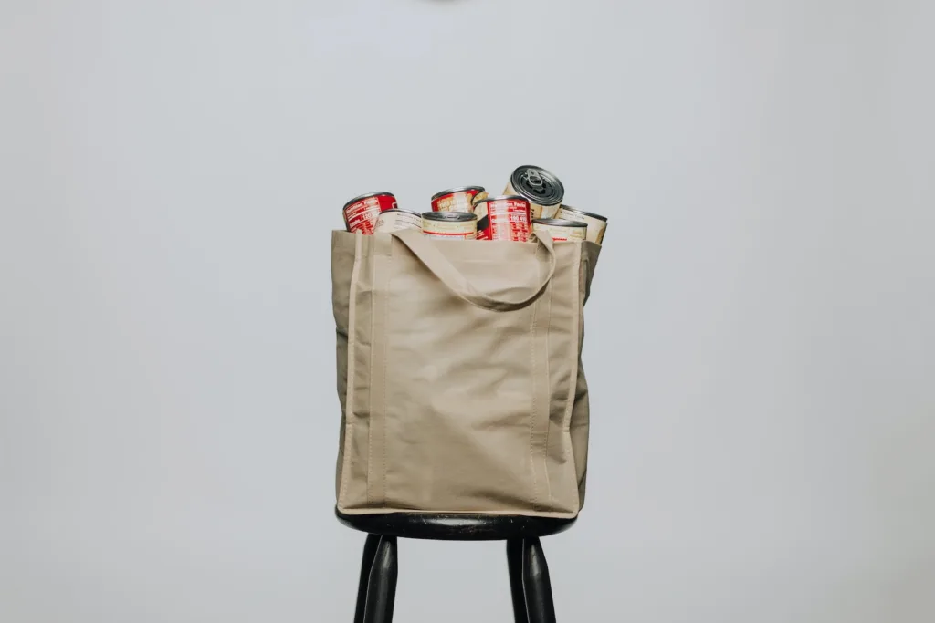 Emergency kit - red labeled cans on white fabric handbag