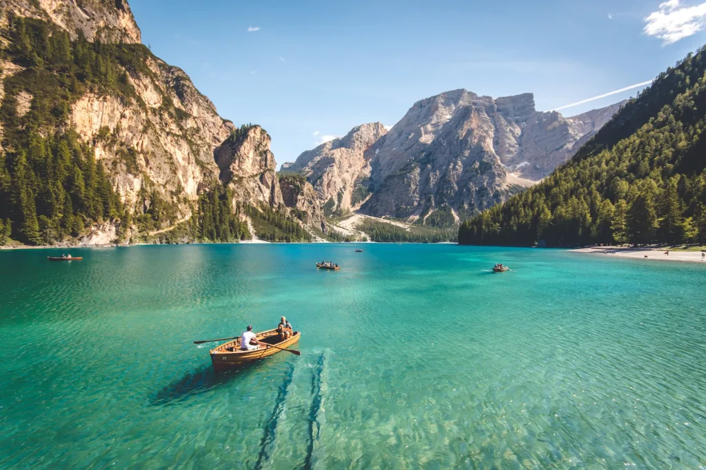 Travel hacks - three brown wooden boat on blue lake water taken at daytime